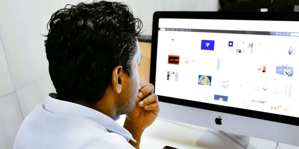 A UI designer in side profile, looking at a computer screen