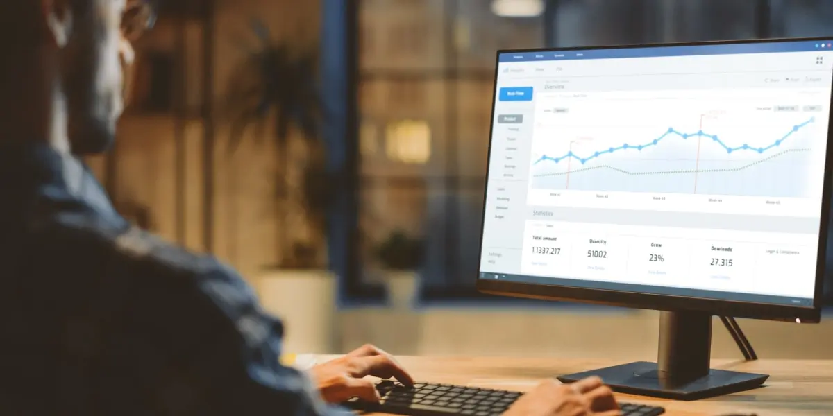 A data analyst looking at graphs on a computer