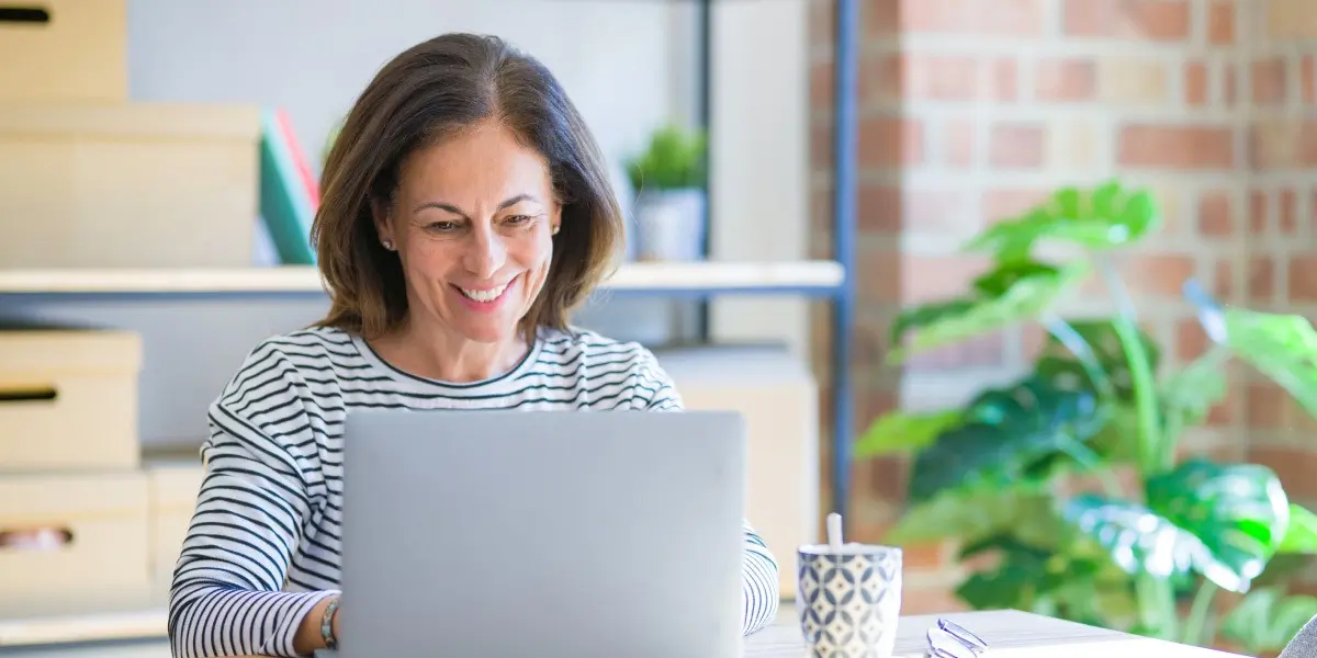 A data analyst working from home, sitting in a kitchen with a laptop