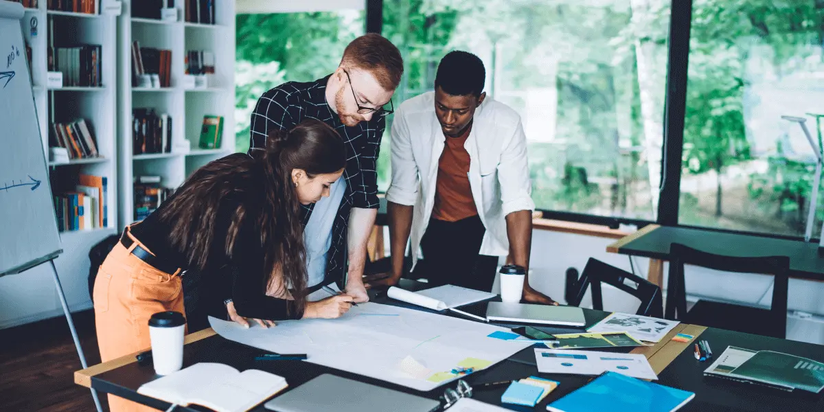 A group of data scientists looking at documents on a desk