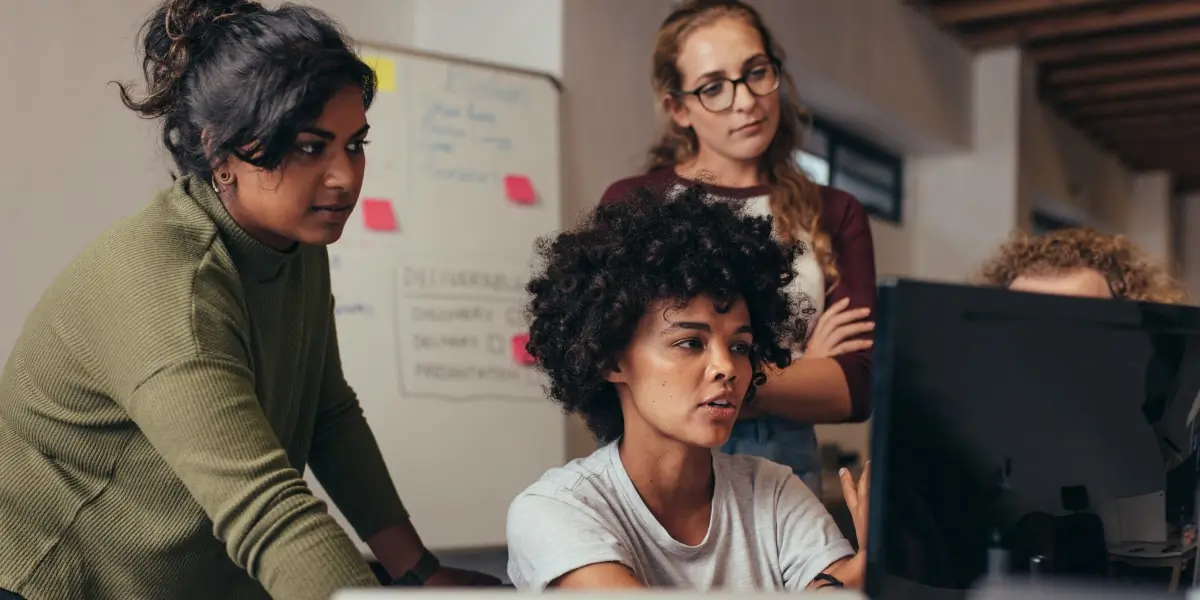 A group of data analysts looking at a computer screen