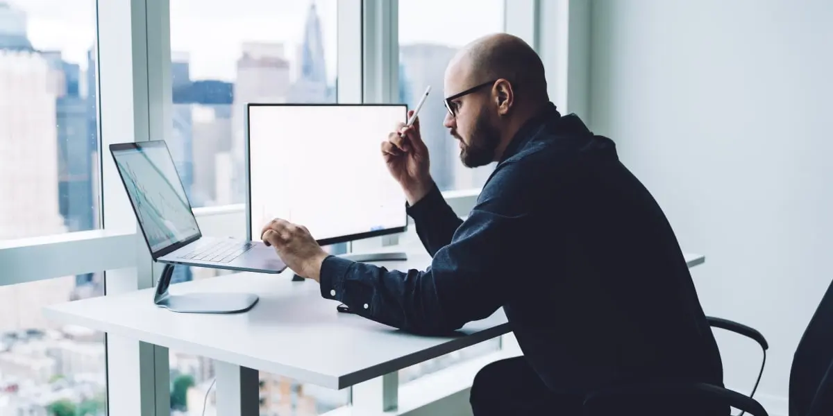 A data analyst sitting at a desk in a modern glass office