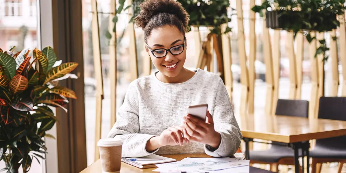 An animation designer looking at a phone screen, smiling