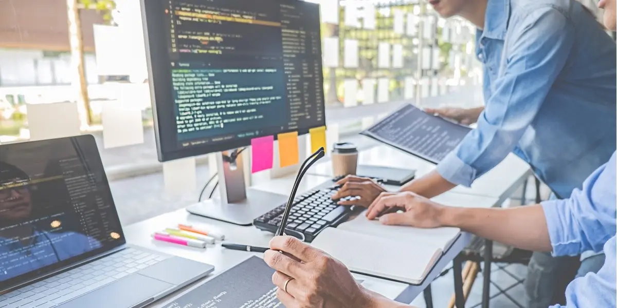 A designer working at a computer, looking at some code