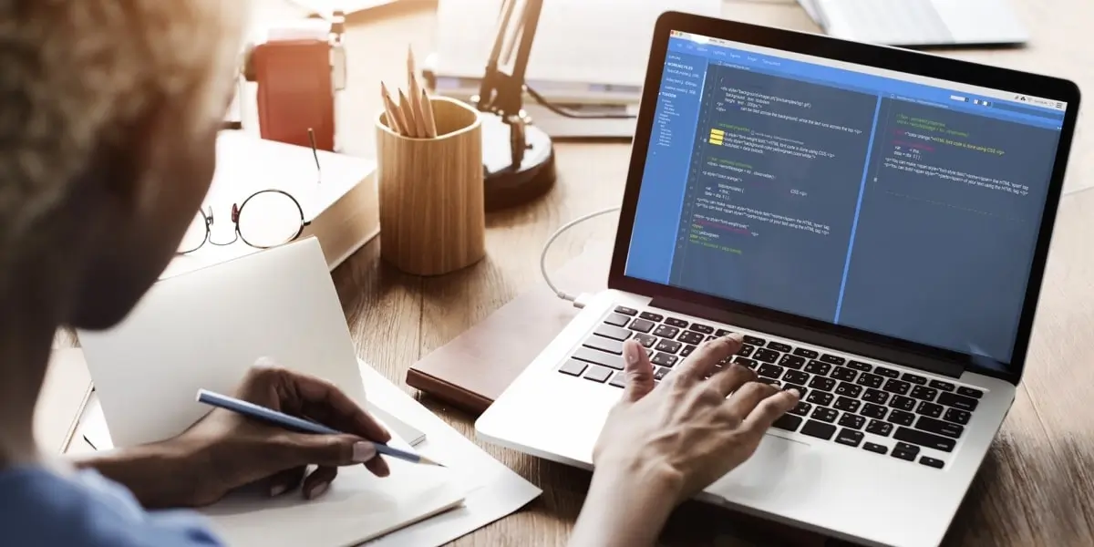 A Bootstrap developer looks at a laptop screen of code.
