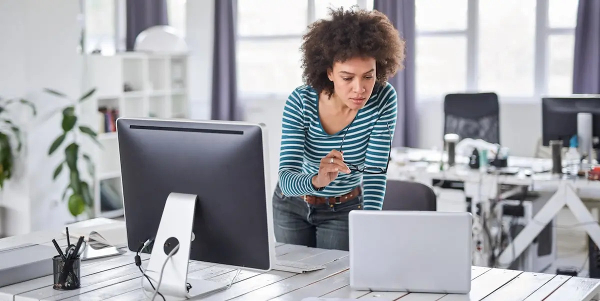 A woman takes a free online data analytics course on her desktop computer.