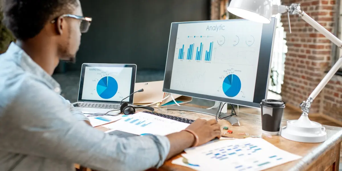 A digital marketing analyst looking at data and graphs on a computer