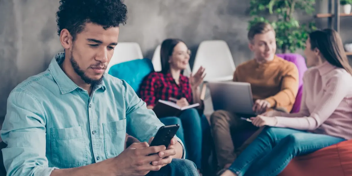 A startup worker looking at a smartphone, researching SEO vs SEM