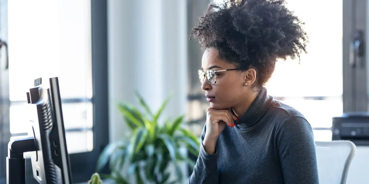 A digital marketing manager in side profile, looking at a computer screen