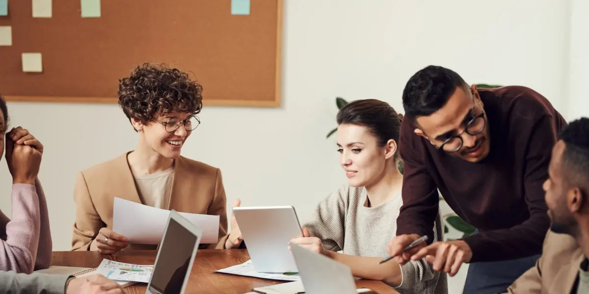 A UX design team sitting at a table discussing a user story