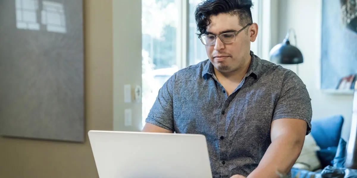 A social media specialist sitting at a desk, looking at a computer