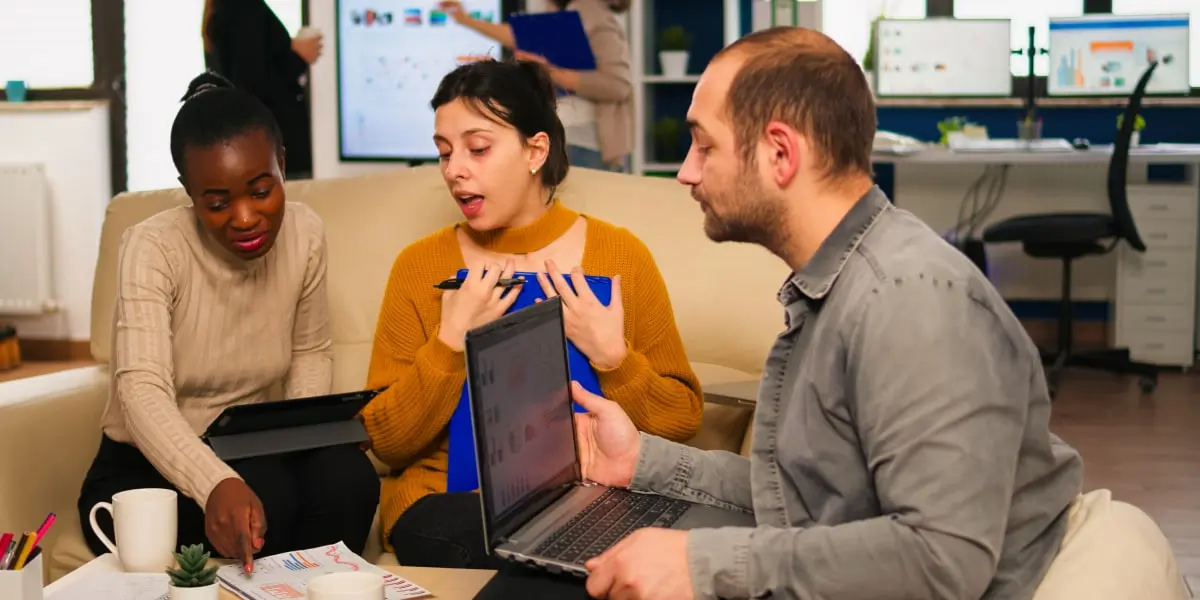 A group of digital marketing agency workers sitting in an office, discussing a project