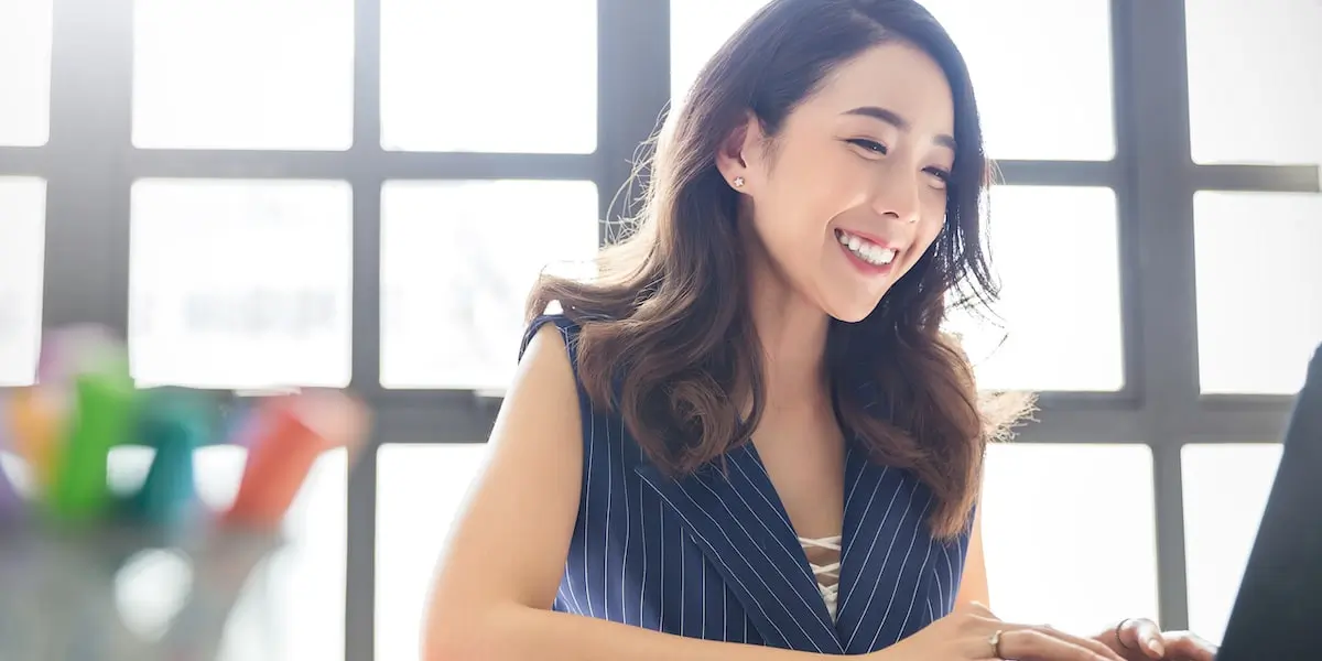 Woman working at her computer comparing marketing associate salary differences across regions