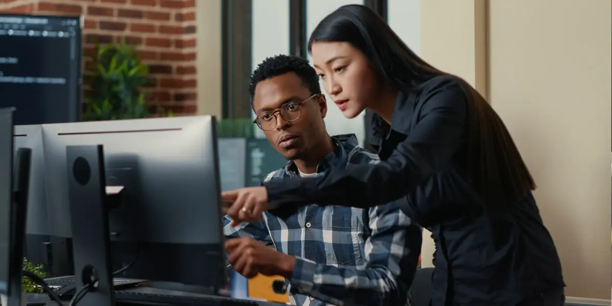 Two cloud computing engineers working with AWS in an office.