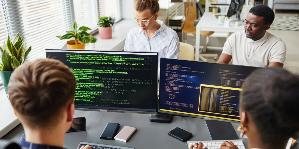 Image of dour developers in an office deciding on the best coding language to learn.