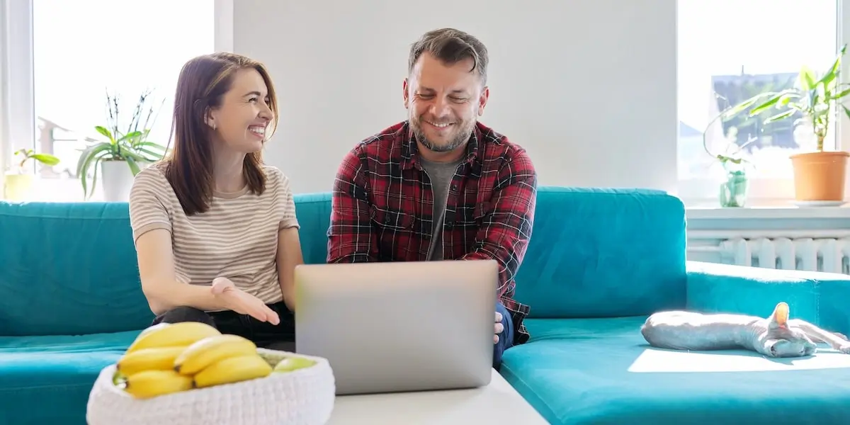 A coder earning a frontend developer salary discusses something with a colleague on his laptop.