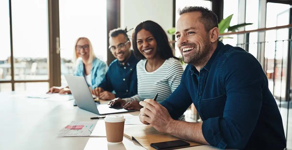 man laughing with colleagues at one of the best tech companies to work for