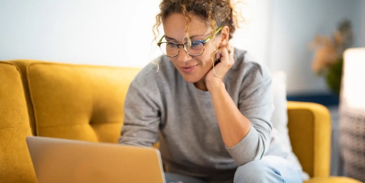 Woman at home on her laptop taking a product management bootcamp.