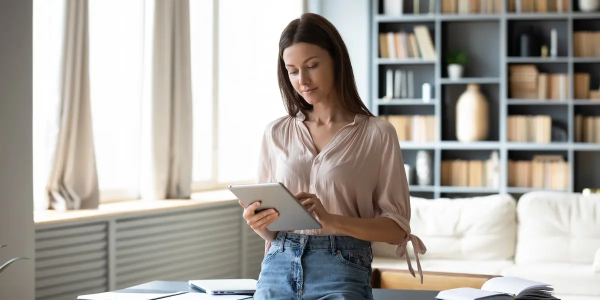 Woman with tablet researching types of social media certifications online.