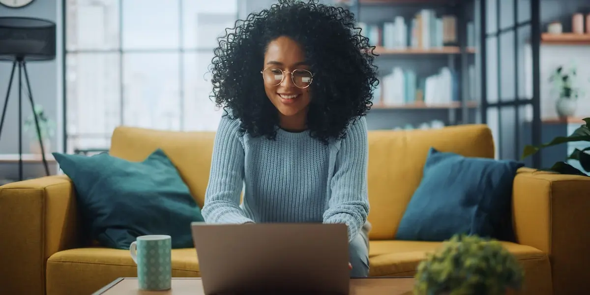 Woman sits at home at her laptop creating her software engineer portfolio.