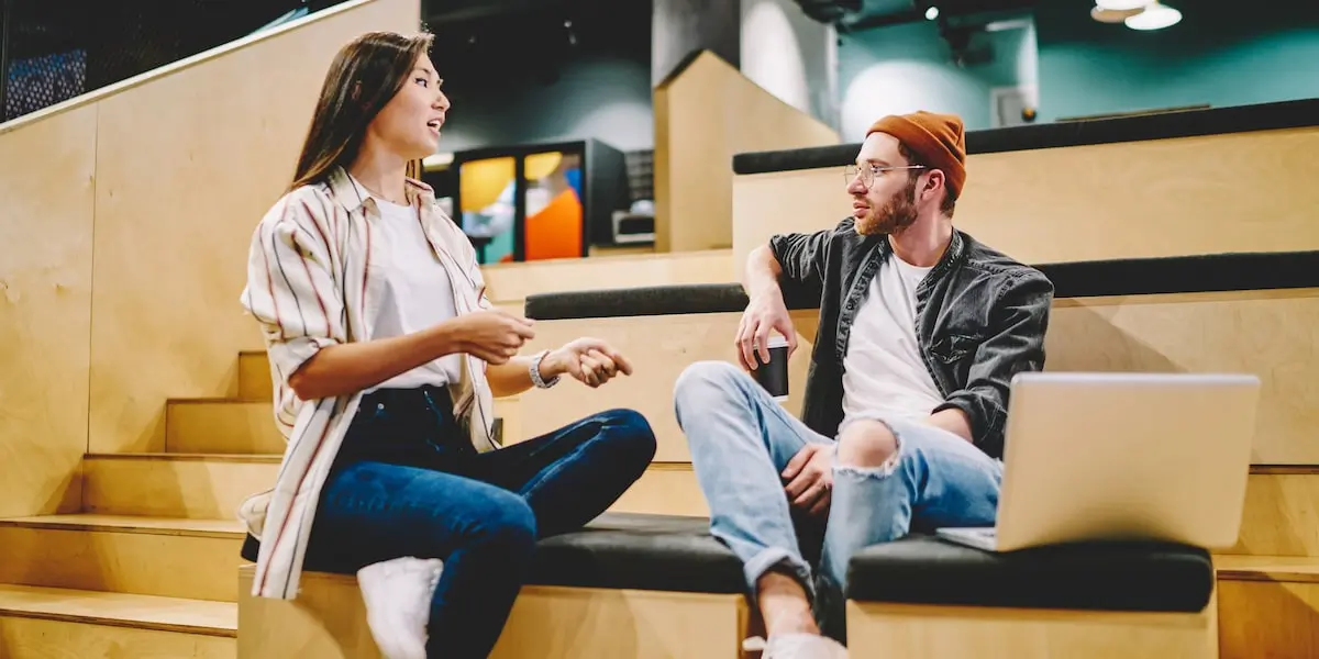 Two people working on social media marketing in a co-working space