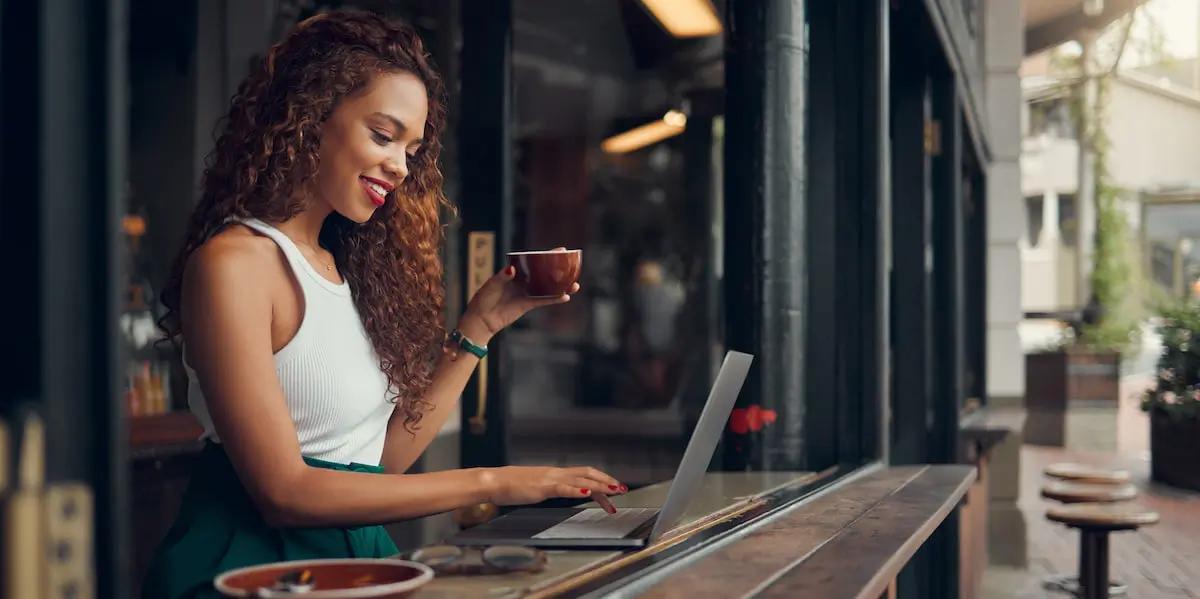 A young tech worker uses the benefits of remote work at a cafe