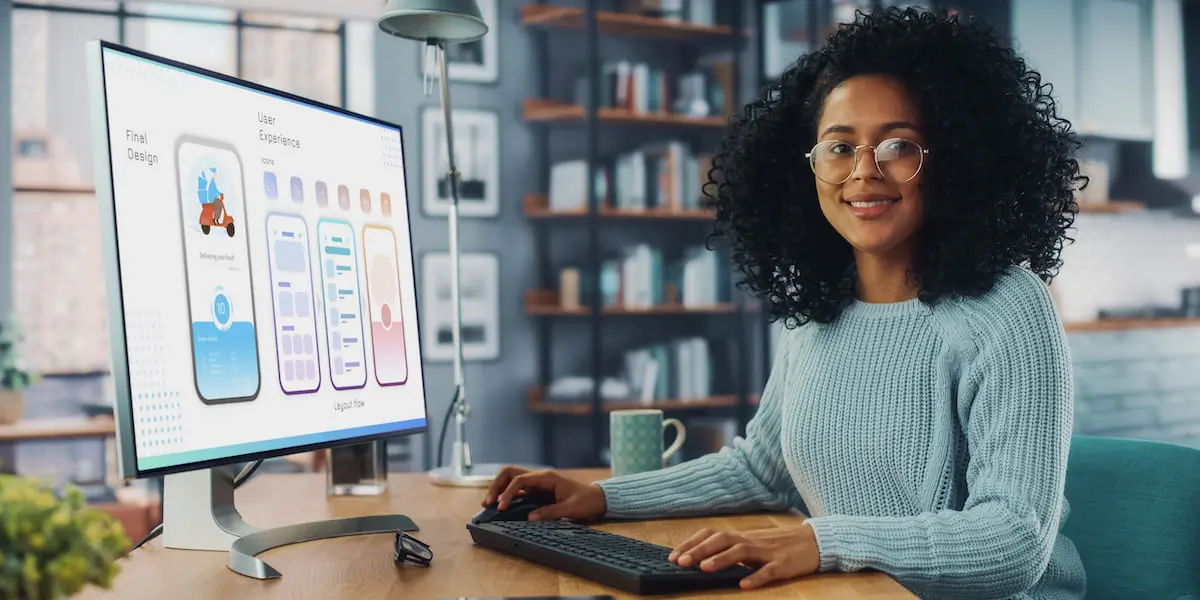 Young woman uses UI design principles at desktop computer