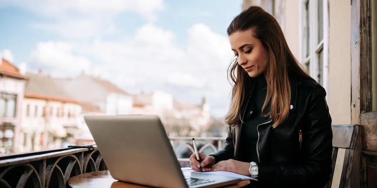 young ui designer planning ui breadcrumbs for website at laptop outside