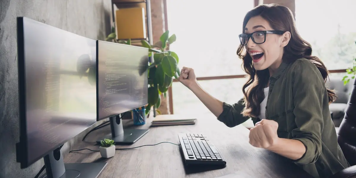 Delighted developer after successfully learning what is debugging in her home office.