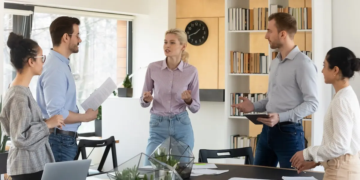 Scrum Master leading a scrum retrospective meeting with her team in a coworking space.