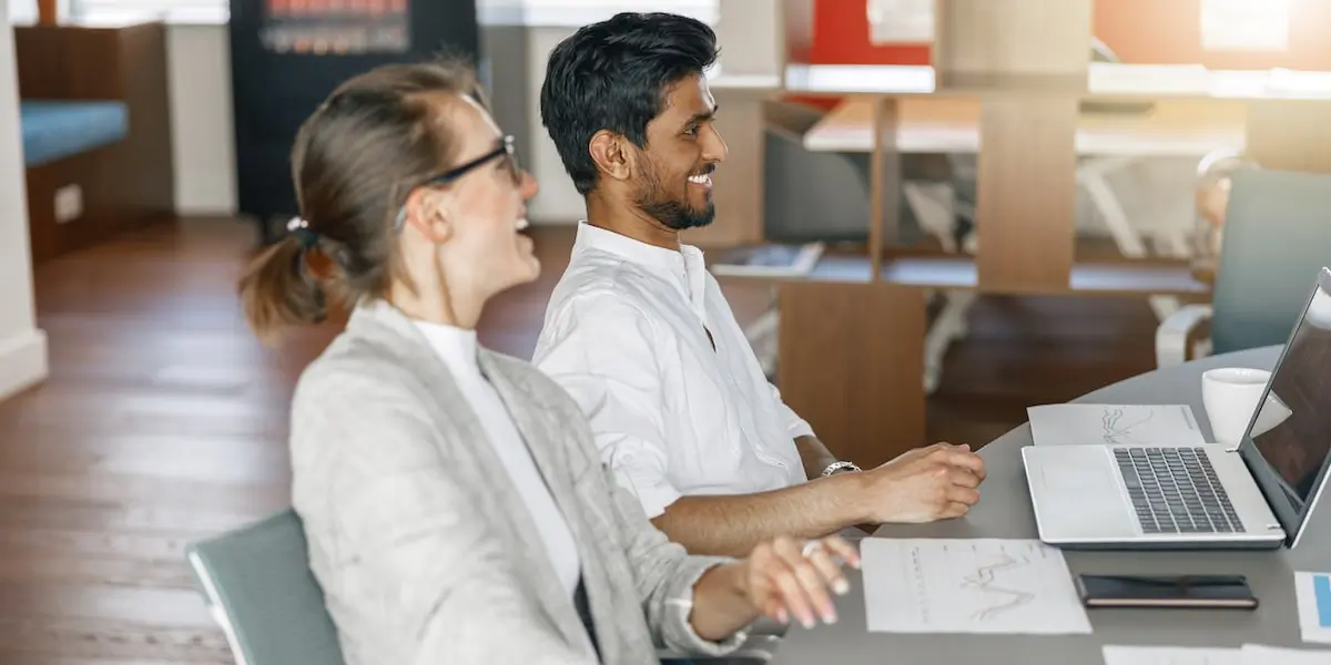 A smiling product manger carrying out stakeholder management on a project in an office.