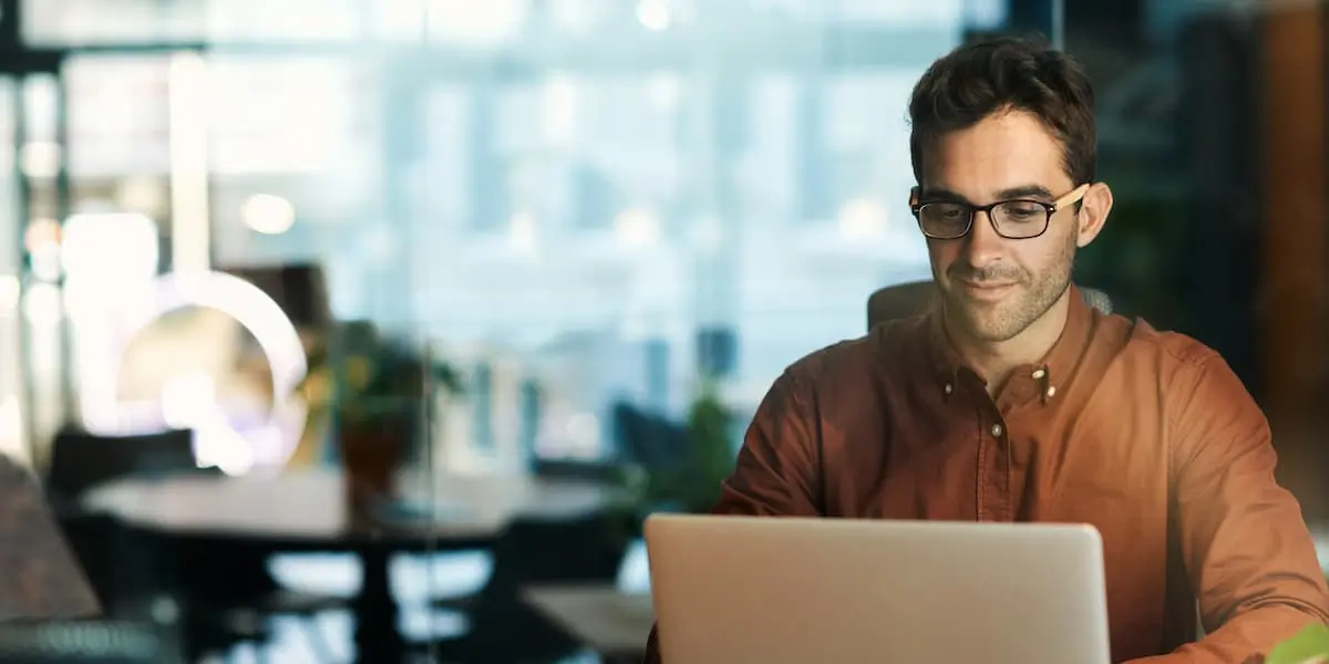 man works at his laptop in a restaurant looking for freelance jobs