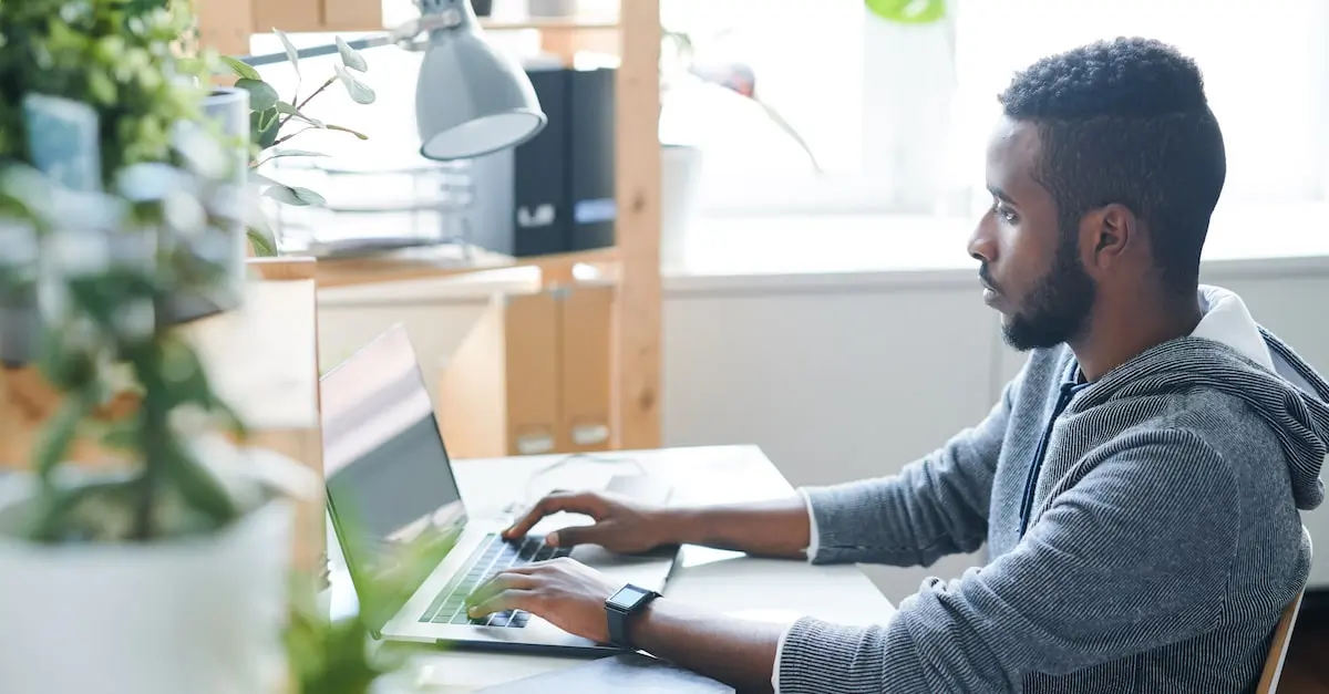 A software architect sitting at a laptop working from a home office.