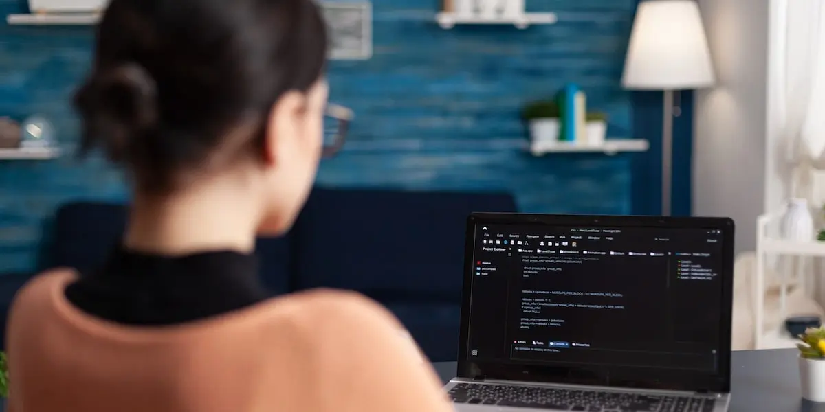 A DevOps engineer working in her home office on her laptop.