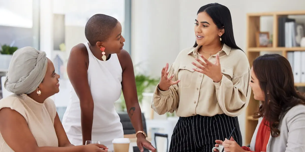 A Director of Product discusses an idea with three of her colleagues in an informal meeting.