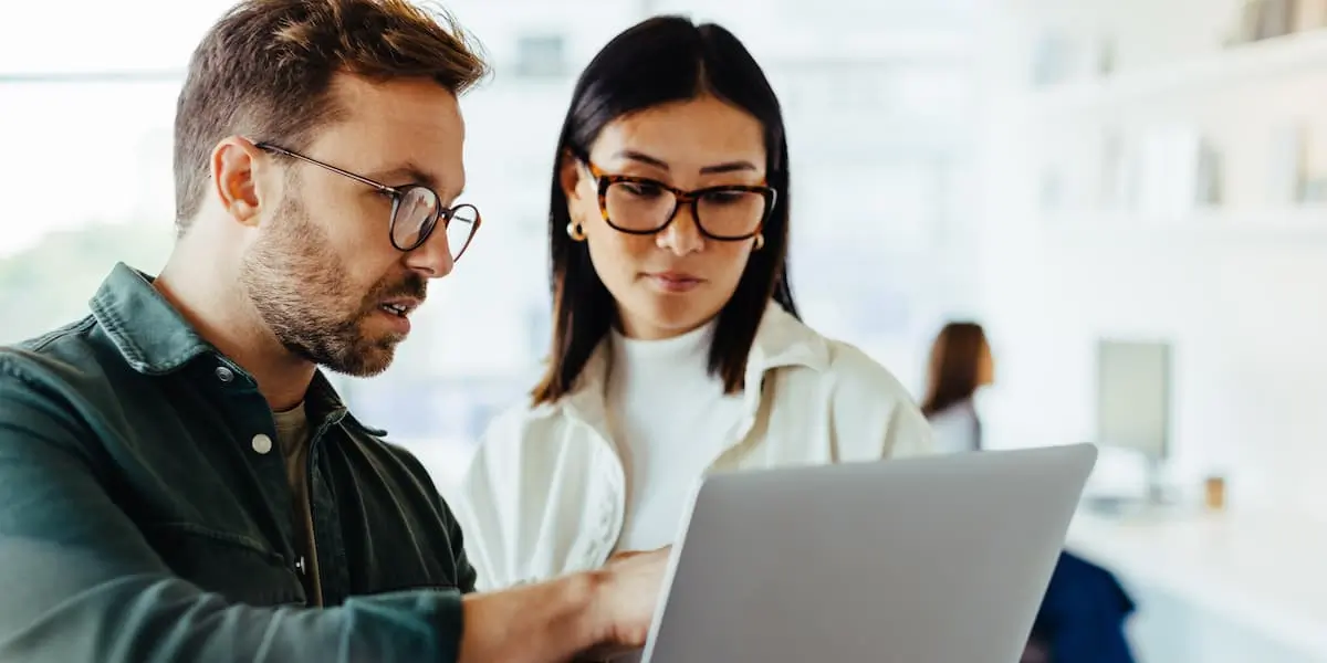 Two digital marketers at a laptop using AI in digital marketing