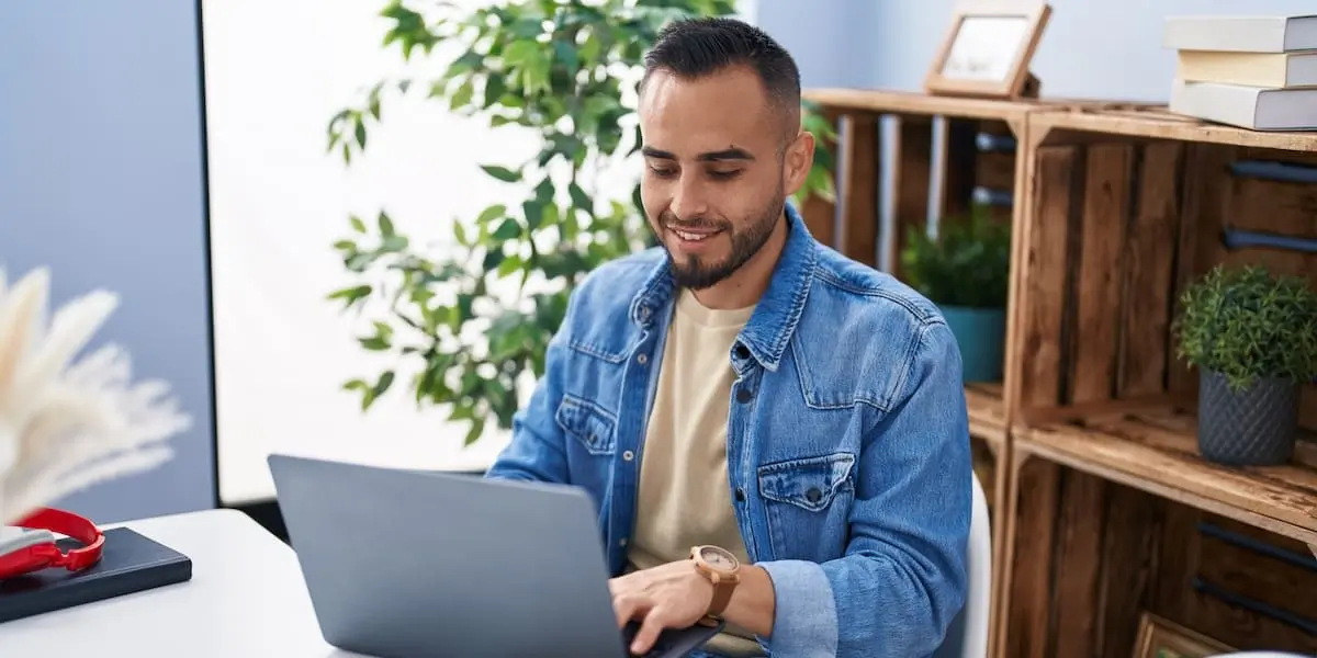 A group product manager works on his laptop in a bright office.