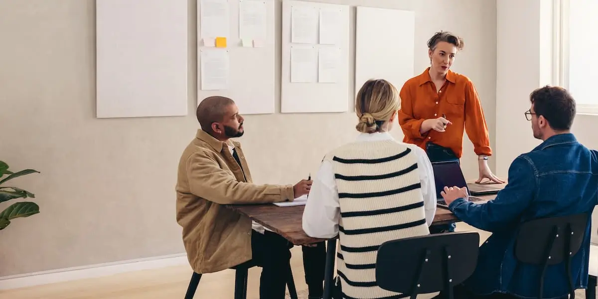 UI designers discussing ai around a table while the team lead stands up