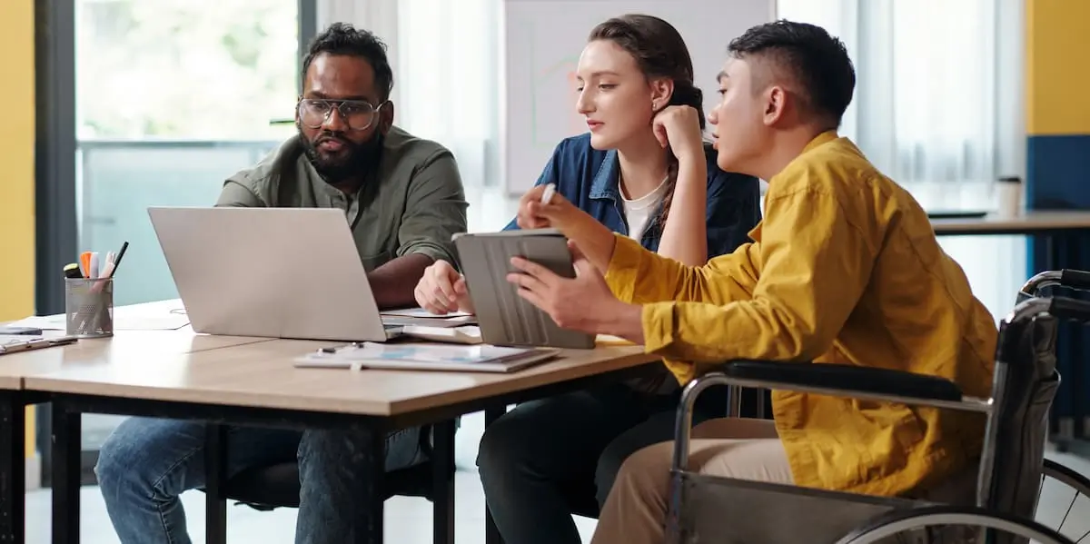 A product owner in a wheelchair conducting backlog refinement with their product team.