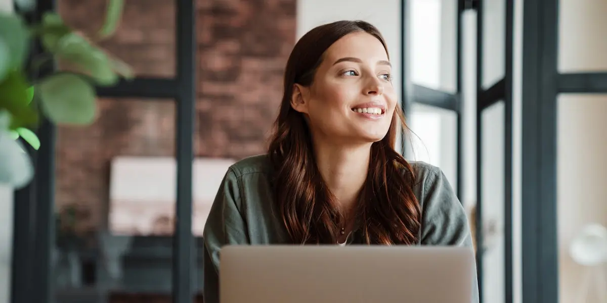 A young woman sits at a laptop after taking the digital marketing quiz