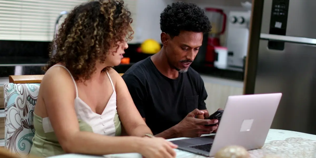 A developer learning AI programming languages sits at his laptop with his mentor.