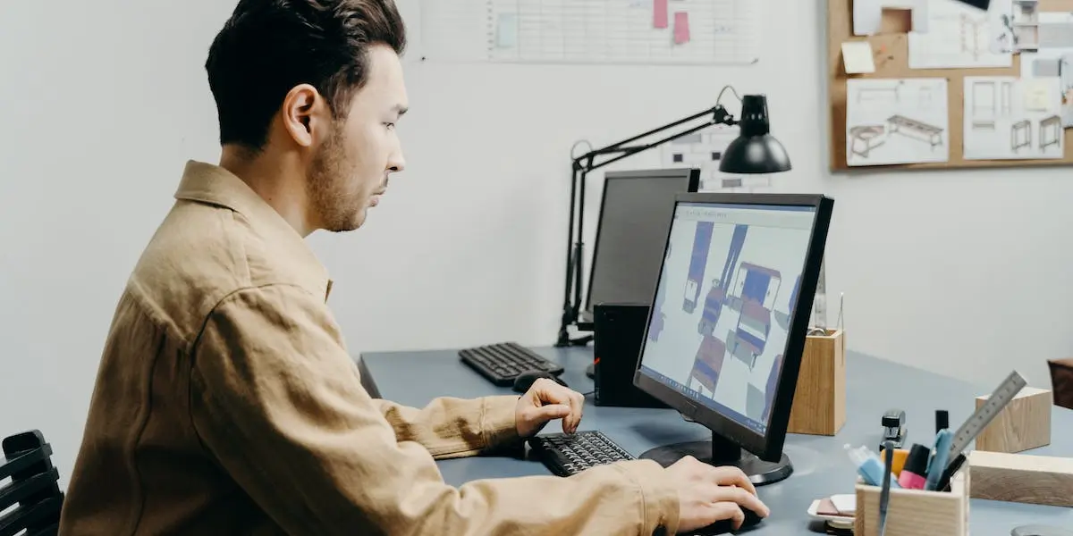 A product designer works away designing furniture on his laptop.