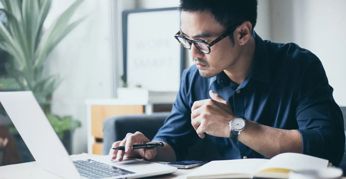 A designer sits at his laptop trying to decide between midjourney vs stable diffusion