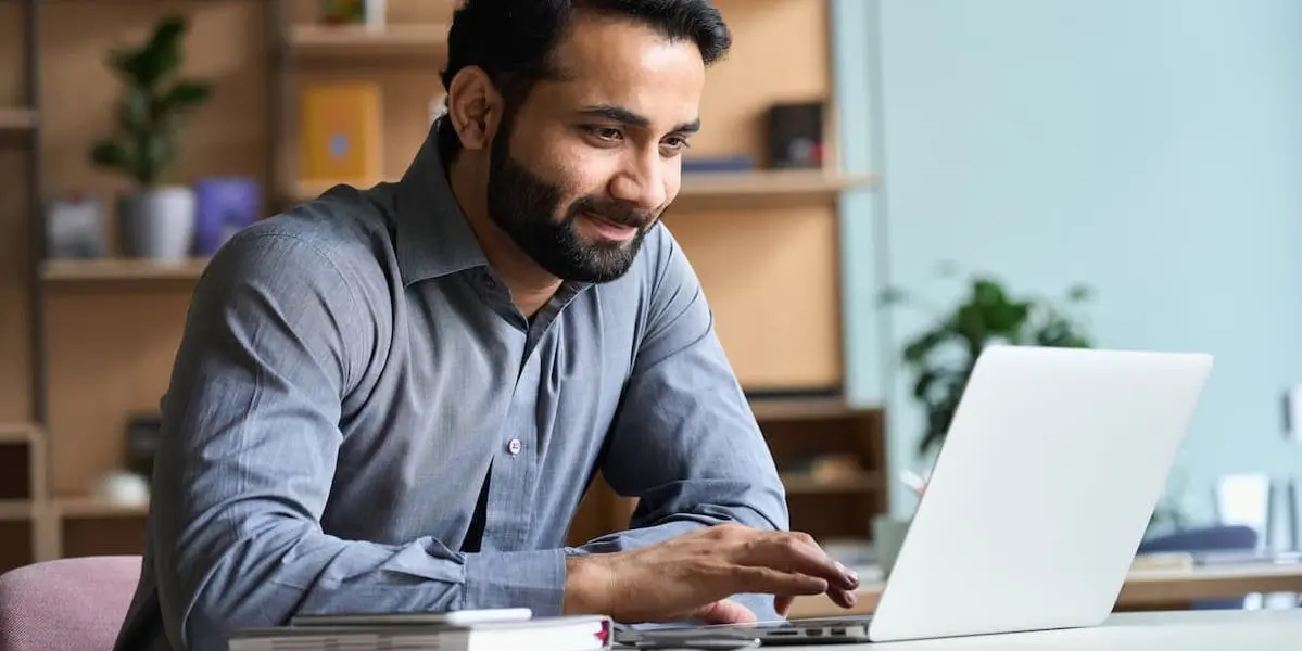 A young man takes an AI certification course on his laptop.