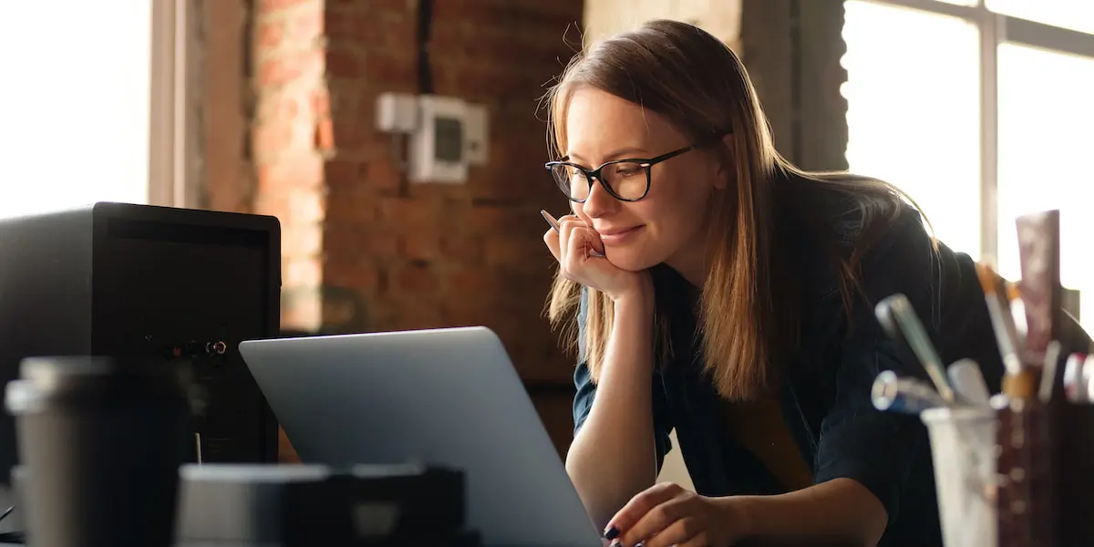 blonde female product designer with glasses at computer